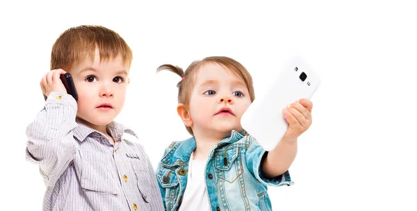 Schattige Kleine Kinderen Met Mobiele Telefoons Knuffelen Geïsoleerd Witte Achtergrond — Stockfoto