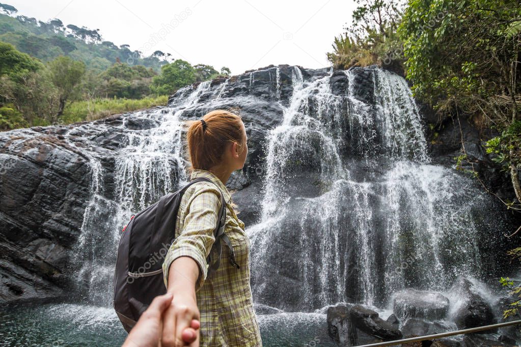 The girl leads to adventure. The girl leads to the waterfall. Baker's Falls, Horton Plains National Park. Sri Lanka. 20-m. waterfall in a picturesque setting amid rocks & ferns, accessed by a moderate footpath.