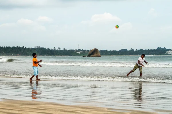 Les gars jouent au ballon sur la plage de l'océan — Photo