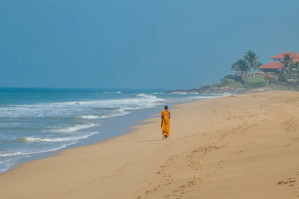 Un monje budista solitario camina a lo largo de la orilla del océano — Foto de Stock
