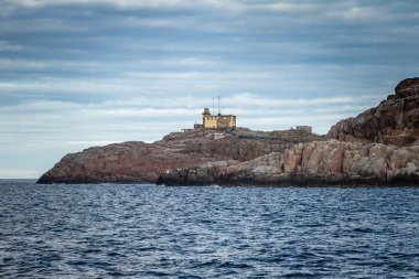 Lighthouse on the rocks. Teriberka. Coast of the Arctic Ocean. R clipart