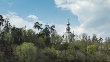 Ormandaki Ortodoks Hıristiyan kilisesi bulutların arka planında. Orta Rusya 'nın eski bir kilisesi olan manzarası. Kutsal Bakire Meryem 'in Varsayımı Kilisesi Trinity-Lykovo' da. Zaman aşımı