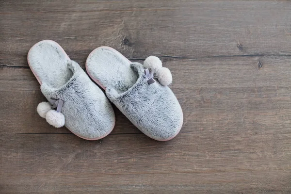 fur slippers on a dark wooden background