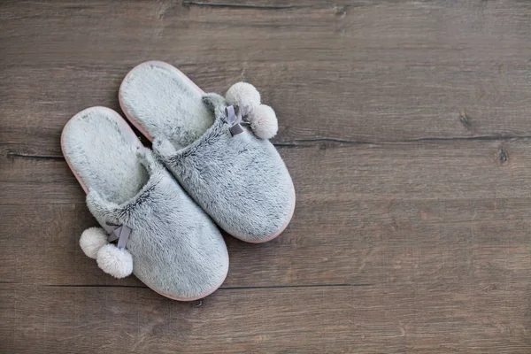 fur slippers on a dark wooden background