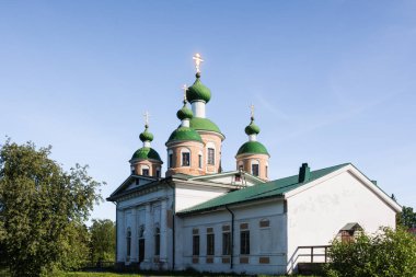 Nehrin ortasında bir adada antik kilise yükselir. Güneş kubbeler oynuyor. Mavi gökyüzü nehre yansıtılır. Olonets, Karelya, Rusya Federasyonu
