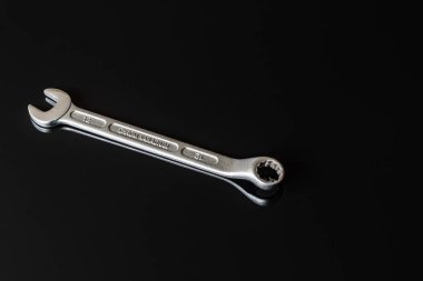 Metal vidalar, pullar, fındık ve anahtarları bir siyah arka plan ayna. Harika kontrast görüntü