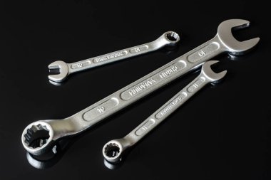 Metal vidalar, pullar, fındık ve anahtarları bir siyah arka plan ayna. Harika kontrast görüntü