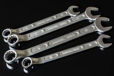 Metal vidalar, pullar, fındık ve anahtarları bir siyah arka plan ayna. Harika kontrast görüntü