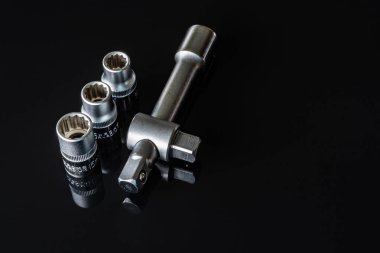 Metal vidalar, pullar, fındık ve anahtarları bir siyah arka plan ayna. Harika kontrast görüntü