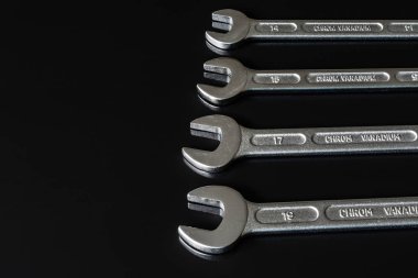 Metal vidalar, pullar, fındık ve anahtarları bir siyah arka plan ayna. Harika kontrast görüntü