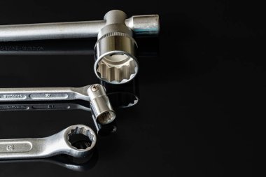 Metal vidalar, pullar, fındık ve anahtarları bir siyah arka plan ayna. Harika kontrast görüntü