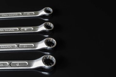 Metal vidalar, pullar, fındık ve anahtarları bir siyah arka plan ayna. Harika kontrast görüntü