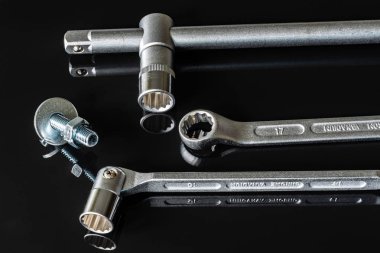 Metal vidalar, pullar, fındık ve anahtarları bir siyah arka plan ayna. Harika kontrast görüntü