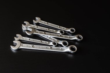 Metal vidalar, pullar, fındık ve anahtarları bir siyah arka plan ayna. Harika kontrast görüntü