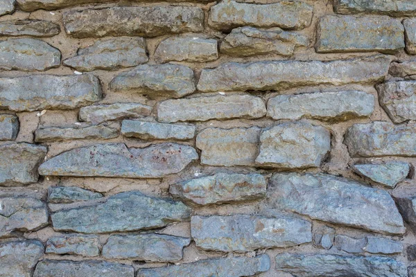 De oude muur van grijze stenen — Stockfoto