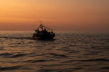 Silhonette turuncu günbatımı gökyüzü karşı denizde Yelkenli bir gemi