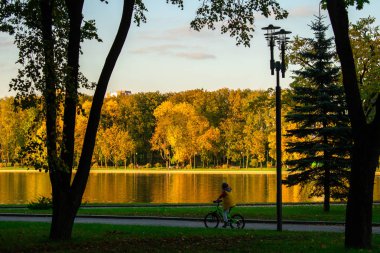 Çocuk arka planda Nehri'nin sonbahar parkta bisikletle