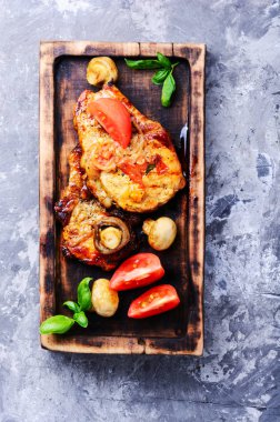 Biftek ızgara et, domates, otlar ve baharatlar kesme tahtası üzerinde