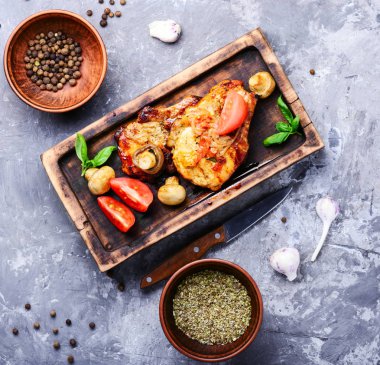 Biftek ızgara et, domates, otlar ve baharatlar kesme tahtası üzerinde