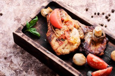 Biftek ızgara et, domates, otlar ve baharatlar kesme tahtası üzerinde