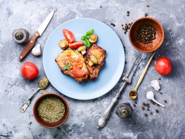 Biftek ızgara et, domates, otlar ve baharatlar plaka üzerinde. Barbekü et