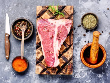 Çiğ mermer et biftek, biber eski ahşap tahta üzerinde. Dana kaburga eti