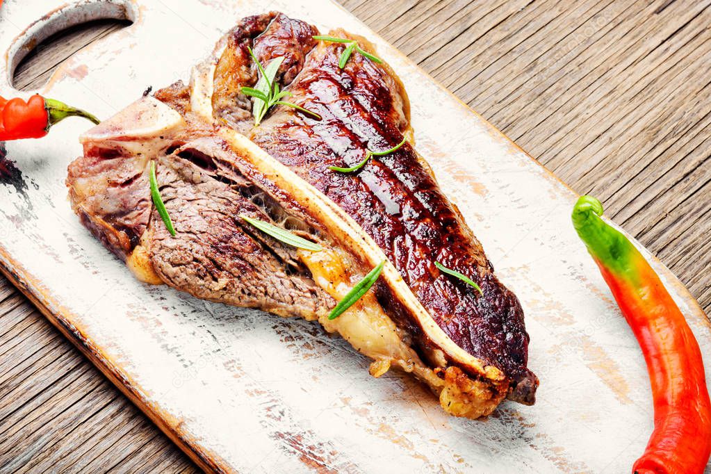 Grilled ribeye beef steak with spices on cutting board