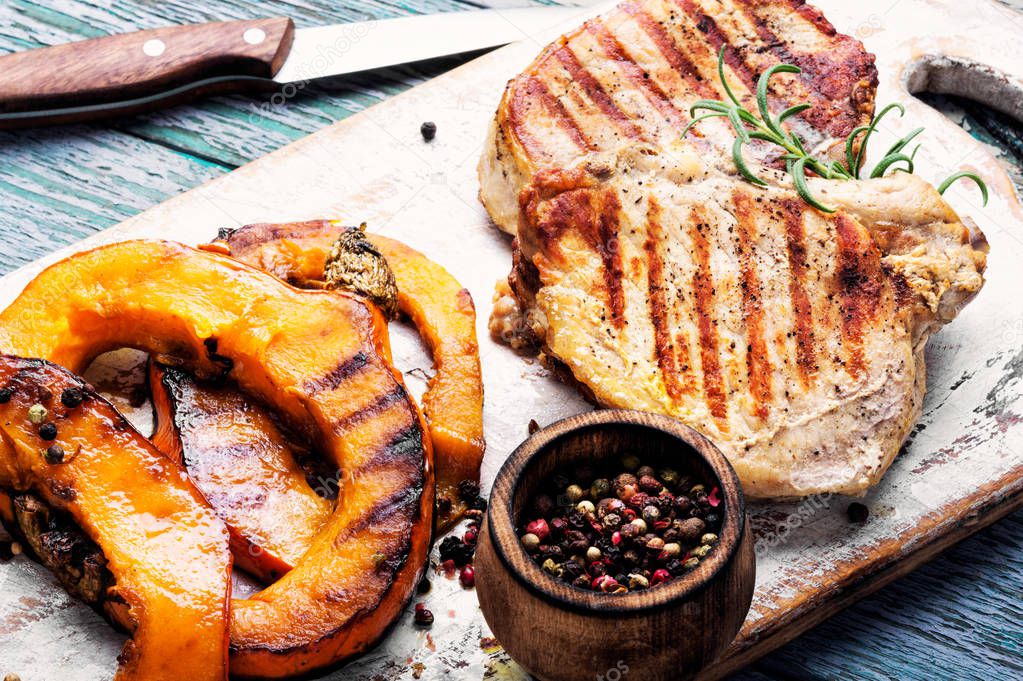 Baked meat with pumpkin on cutting board.Steak with pumpkin