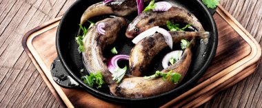 Mutfak masasının üzerinde bir tavada taze deniz balık. Gobiidae balık