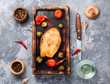 Domates, biber ve lahana ile fırında somon. Sebze garnitürlü balık bifteği. Sağlıklı yemek için balık.