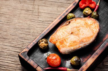 Ahşap arka planda somon bifteği. Sebzeli balık bifteği. Balık yemi. Izgara taze balık.