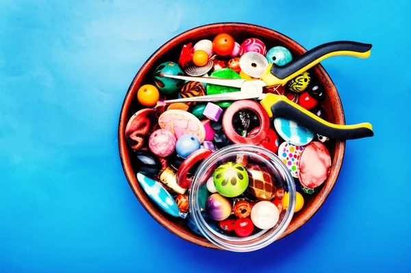 Jewelry making and beading process.Bead mix on blue background