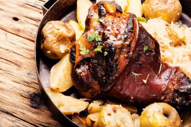 Ahşap yüzeyde domuz budu. Patatesli domuz budu.