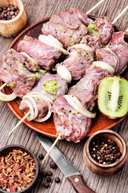 Taze çiğ sığır eti fileto şiş şiş üzerinde. Kivi batırılmış et