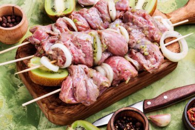 Taze çiğ sığır eti fileto şiş şiş üzerinde. Kivi et batırılmış. Uzun banner