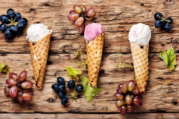 Ice cream sundae, waffle cone.Grape ice cream.Ice cream cones on wooden table