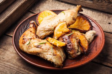 Baked chicken with orange sauce on the plate clipart