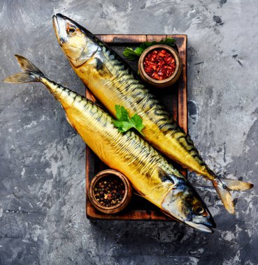 Mutfak tahtasındaki iştah açıcı füme balık. Mısırlı uskumru. Baharatlı balık.