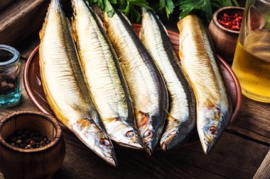 Mutfak tahtasındaki iştah açıcı füme balık. Saury. Baharatlı balık.