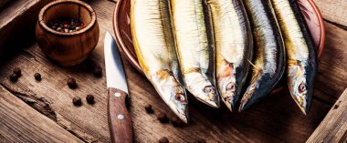 Mutfak tahtasındaki iştah açıcı füme balık. Saury. Baharatlı balık.