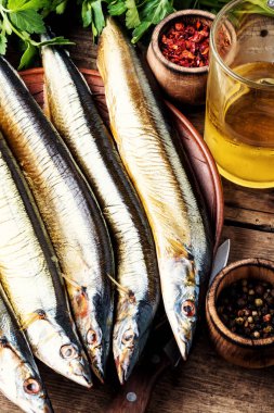 Mutfak tahtasındaki iştah açıcı füme balık. Saury. Baharatlı balık.