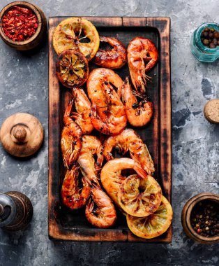 Kızarmış karides ve limon kesme tahtası üzerinde. Deniz ürünleri, shelfish. Barbekü karides ızgara