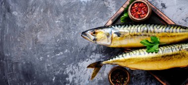 Appetizing smoked fish on kitchen board.Smoked mackerel.Mediterranean food clipart