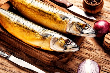 Appetizing smoked fish on kitchen board.Smoked mackerel.Mediterranean food clipart