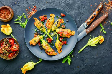 Kurutulmuş domateslerle doldurulmuş lezzetli kızarmış kabak çiçekleri..