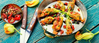 Kurutulmuş domateslerle doldurulmuş lezzetli kızarmış kabak çiçekleri..