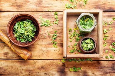 Ahşap masada kurutulmuş yeşil maydanozdan yapılmış konserve.