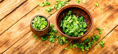 Ahşap masada kurutulmuş maydanozdan yapılmış baharat. Kurutulmuş maydanoz yığını.