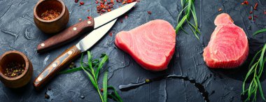 Mutfak masasında taze çiğ ton balığı bifteği ve tarhun.