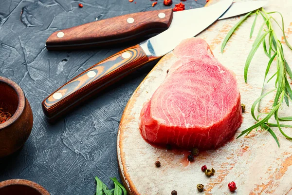 Mutfak tahtasında taze çiğ ton balığı bifteği.